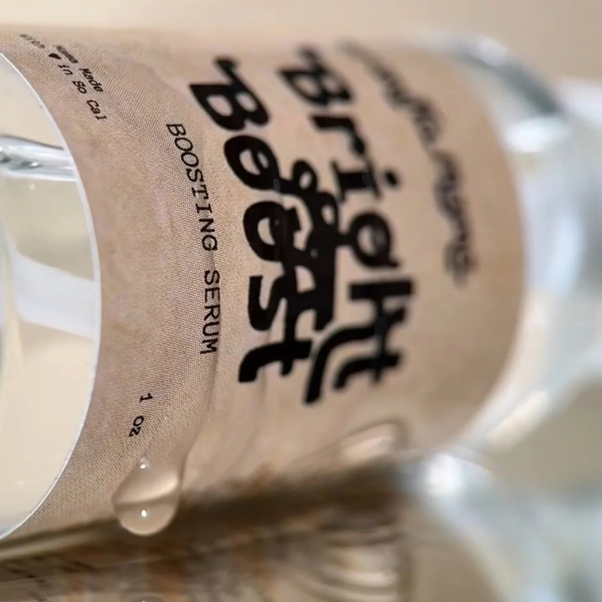 Serum bottle labeled 'bright boost' with a beige background