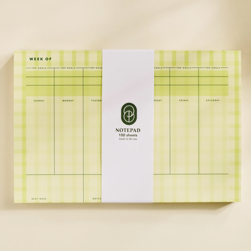 Notepad with green and white design on a beige background