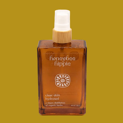 Brown bottle of 'honeybee hippie' clear skin hydrosol on a beige background