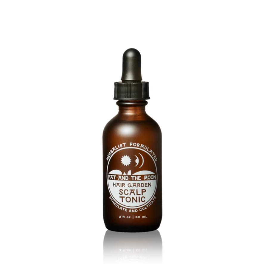 Brown glass bottle with dropper labeled 'Hair Garden Scalp Tonic' on a white background
