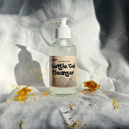 Bottle of 'Gentle Gel Cleanser' on a textured surface with flowers