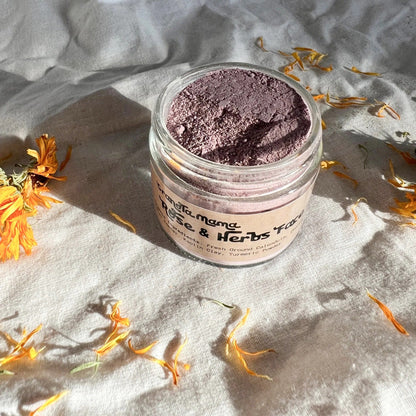 Jar of pink face powder with dried flowers on a textured surface