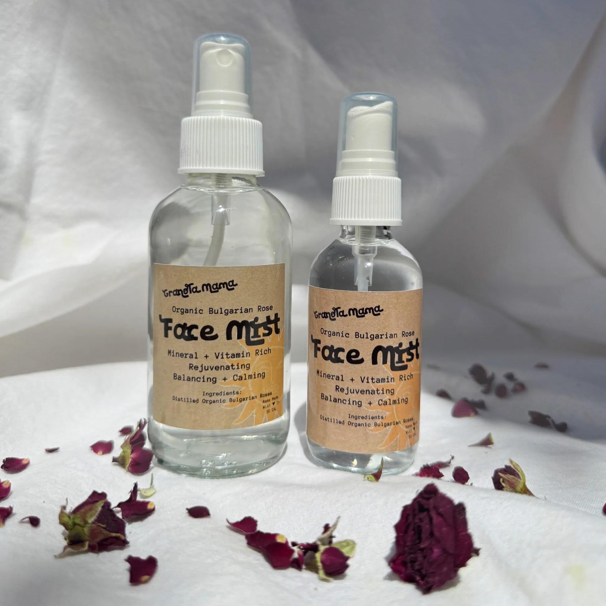 Two bottles of face mist with labels on a white background with dried flowers.