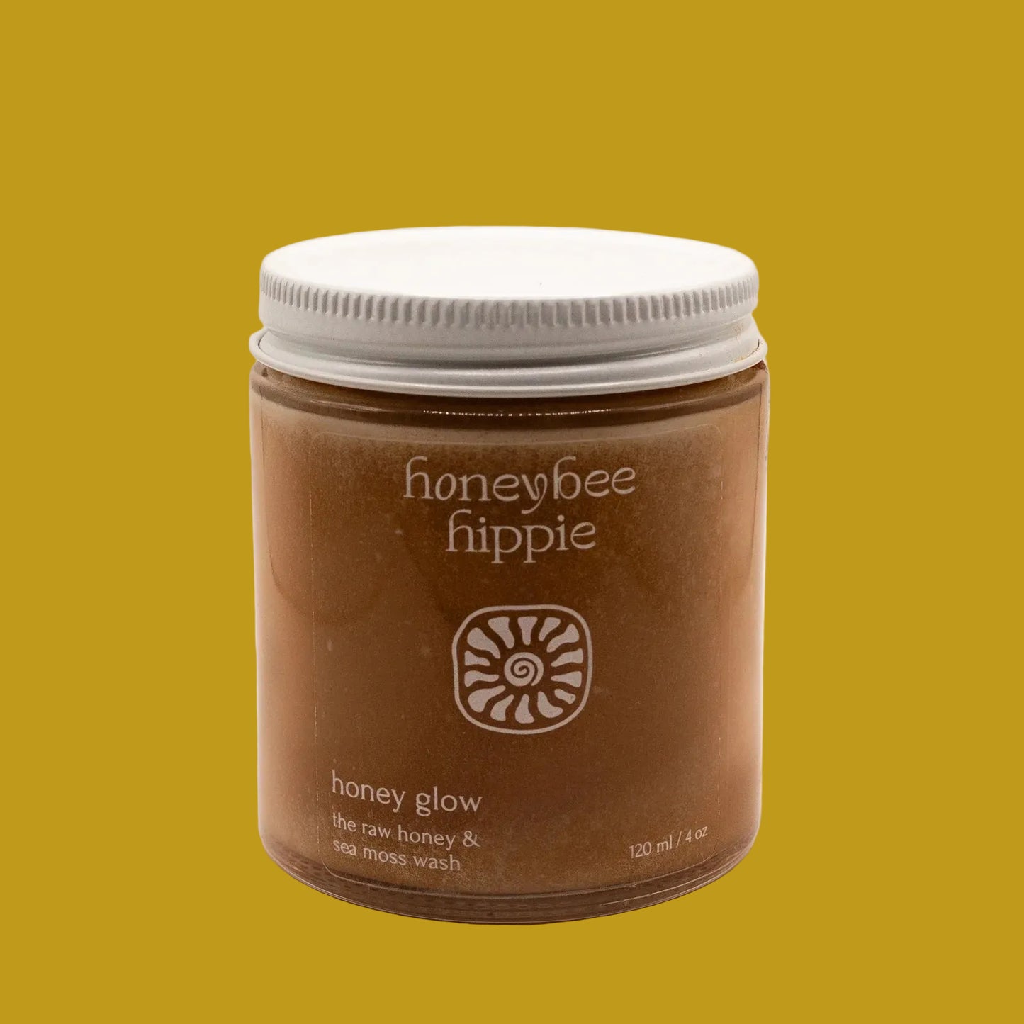 Jar of honeybee hippie honey glow product on a beige background