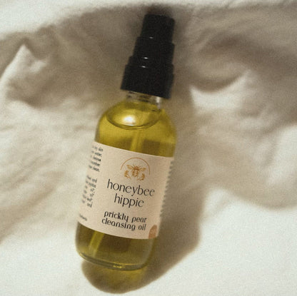Bottle of honeybee hippie prickly pear cleansing oil on a textured surface