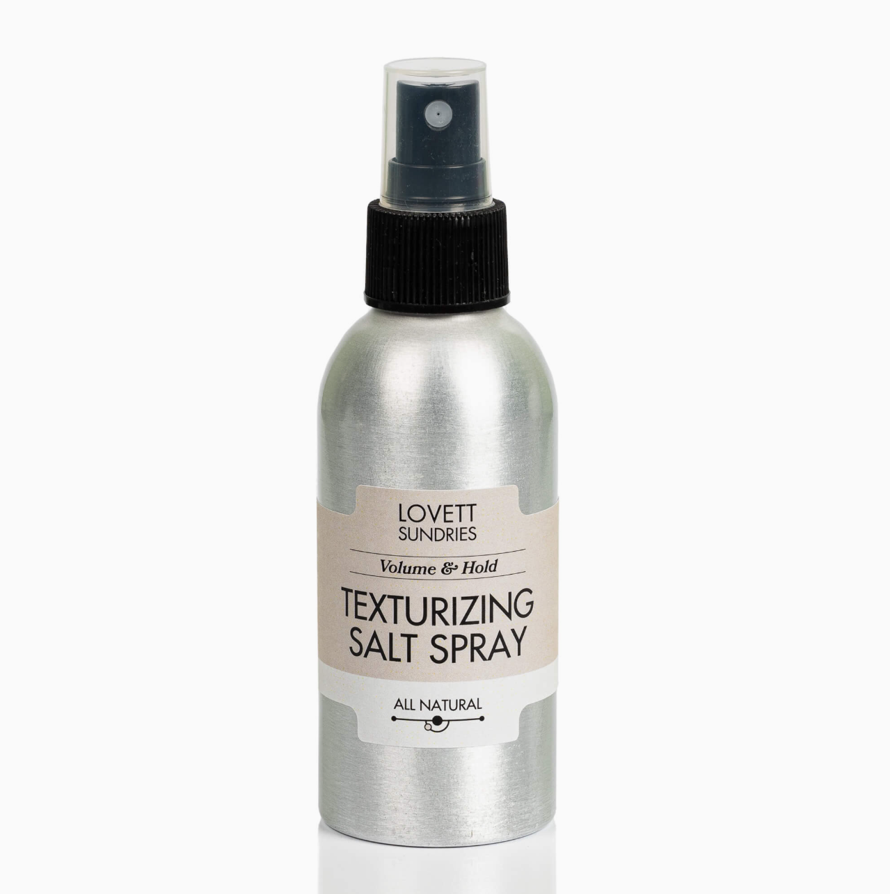 A silver aluminum spray bottle of Lovett Sundries Texturizing Salt Spray with a black spray nozzle and a beige label, set against a plain white background.