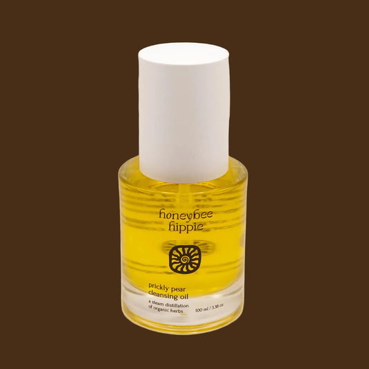 Bottle of honeybee hippie pickly pear cleansing oil on a beige background