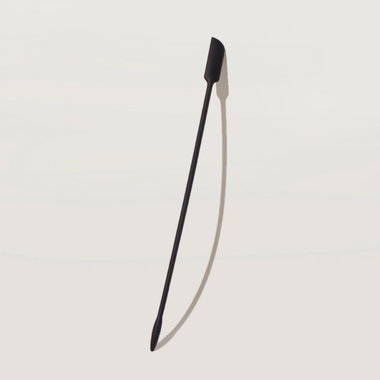 Black thin long spatula on a light gray background