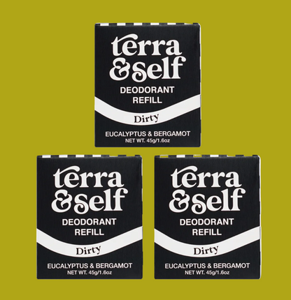 Three black Terra & Self deodorant refill packs arranged on a light gray background, with two packs at the bottom and one pack centered above them.