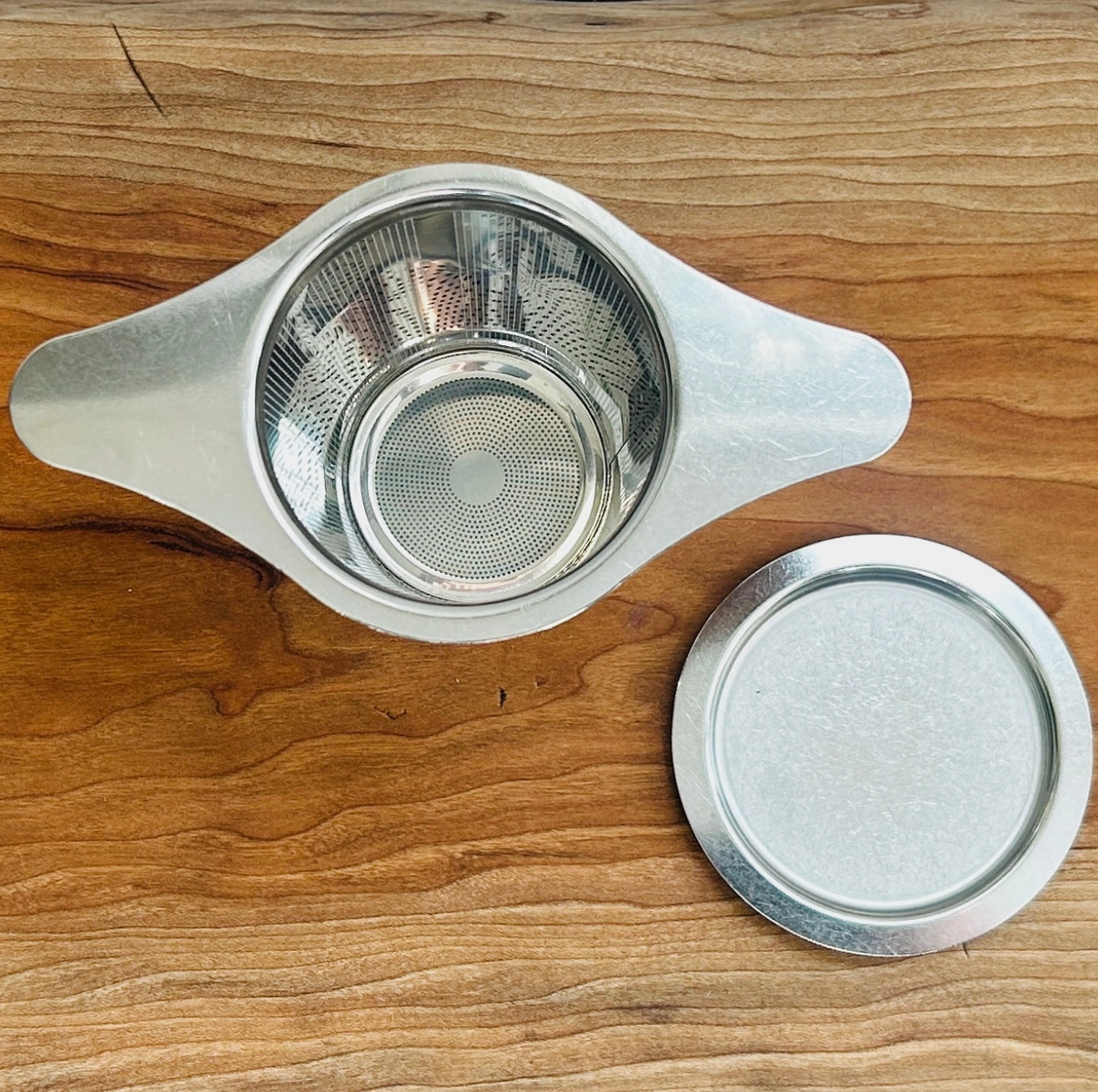 STAINLESS STEEL TEA STEEPER STRAINER SITS ON MUG