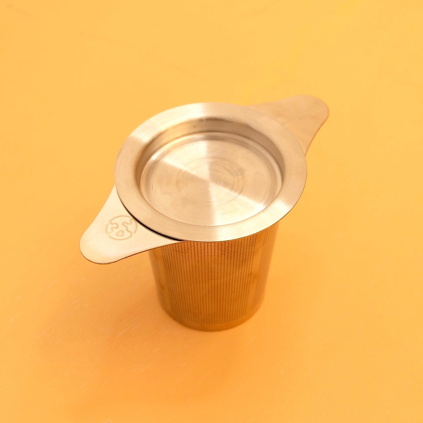 STAINLESS STEEL TEA STEEPER STRAINER SITS ON MUG